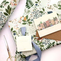Floral-patterned paper with envelopes and a pair of scissors on a white background