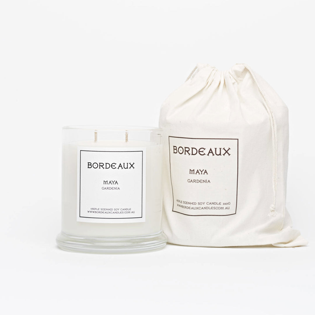 Gardenia fragranced 380g candle in a classic glass jar with knob lid next to a candle in drawstring cotton bag | Bordeaux Candles