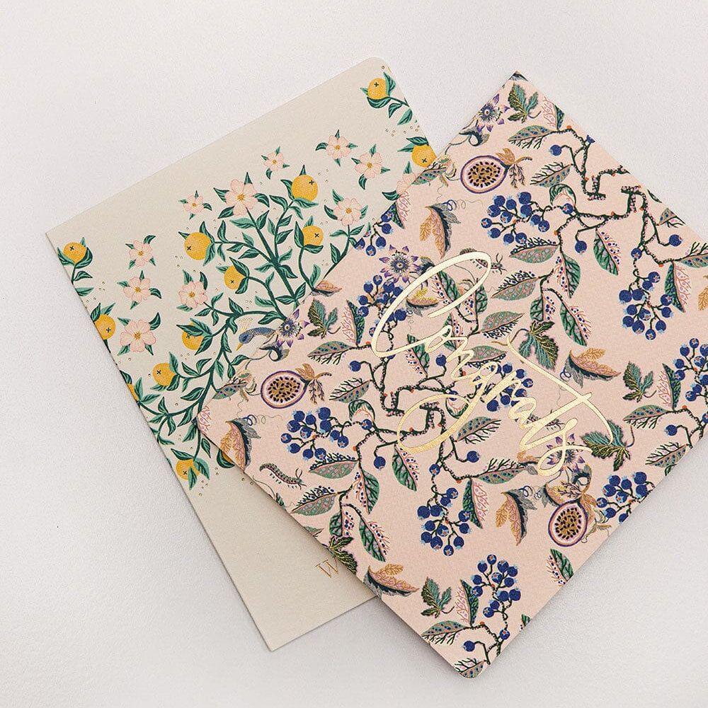 Two floral-patterned notebooks on a light gray background