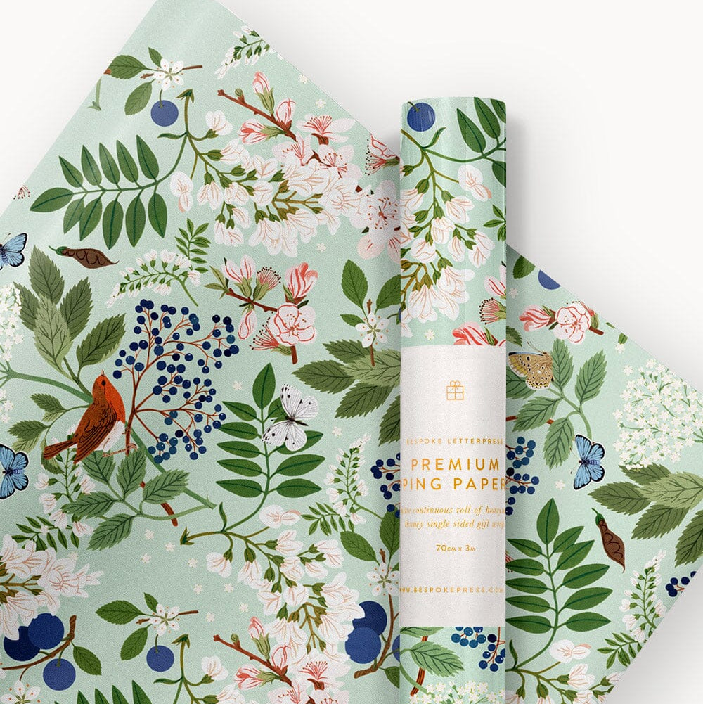 Roll of floral-patterned paper with a visible brand label on a white background