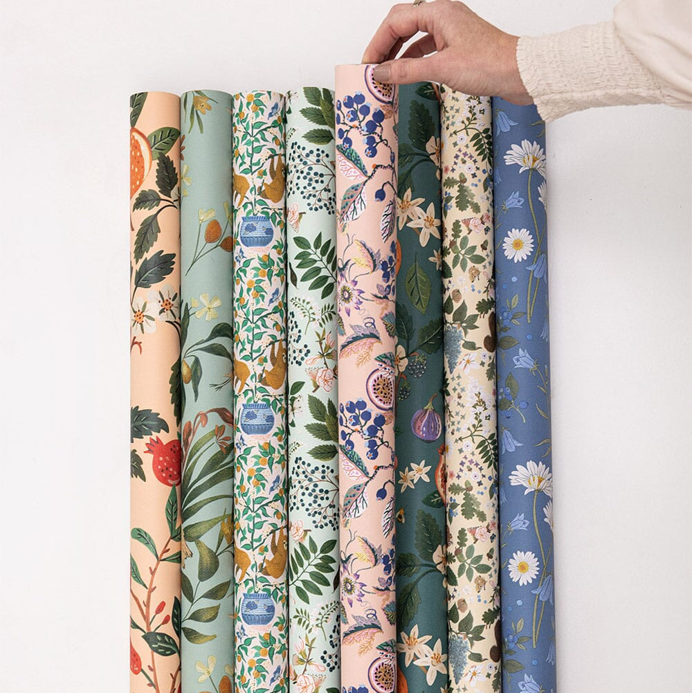 Set of floral-patterned fabric rolls on a white background